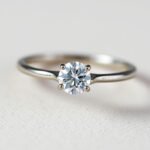 Simple solitaire engagement ring with round diamond on a plain band
