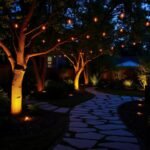 Beautifully lit backyard with string lights and pathway lighting creating a warm ambiance