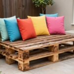DIY pallet couch with colorful cushions in a backyard setting, easy backyard ideas on a budget