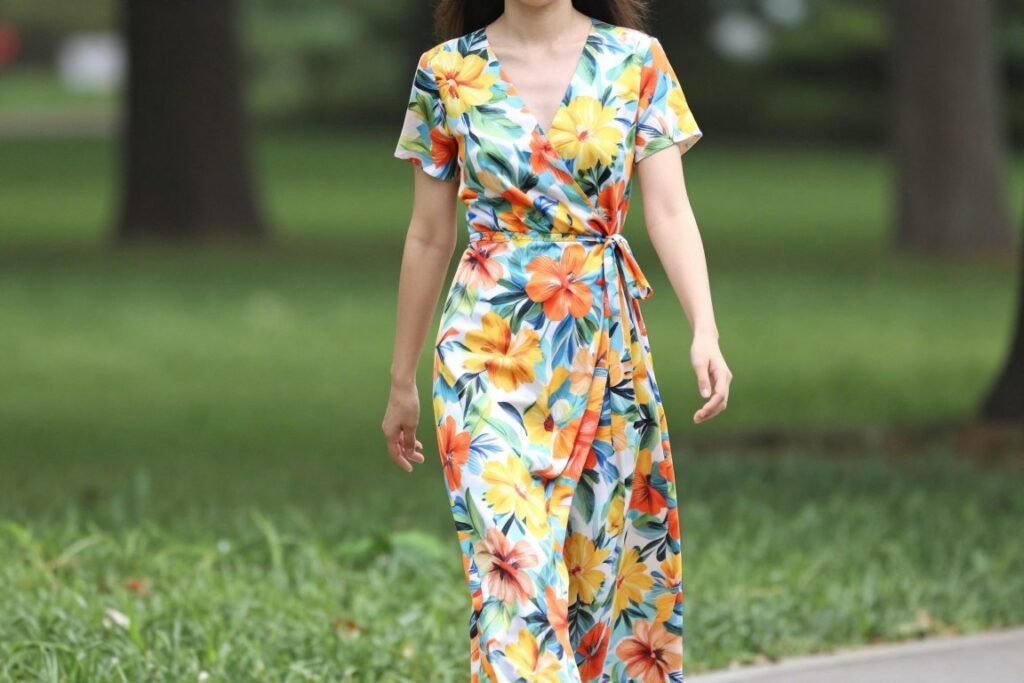 Woman in floral print long wrap dress walking in park