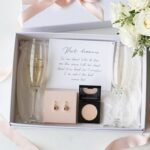 Beautiful bridesmaid proposal gift box with personalized items, ribbons, and flowers on elegant table setting