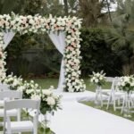 Beautifully decorated wedding ceremony space with floral arch and aisle decorations