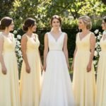 Butter yellow bridesmaid dresses in garden wedding setting with natural sunlight