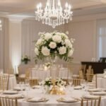 Elegant classic wedding reception with white and gold decorations, crystal chandeliers, and floral centerpieces