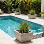 Elegant modern pool surrounded by large contemporary planters with tropical plants