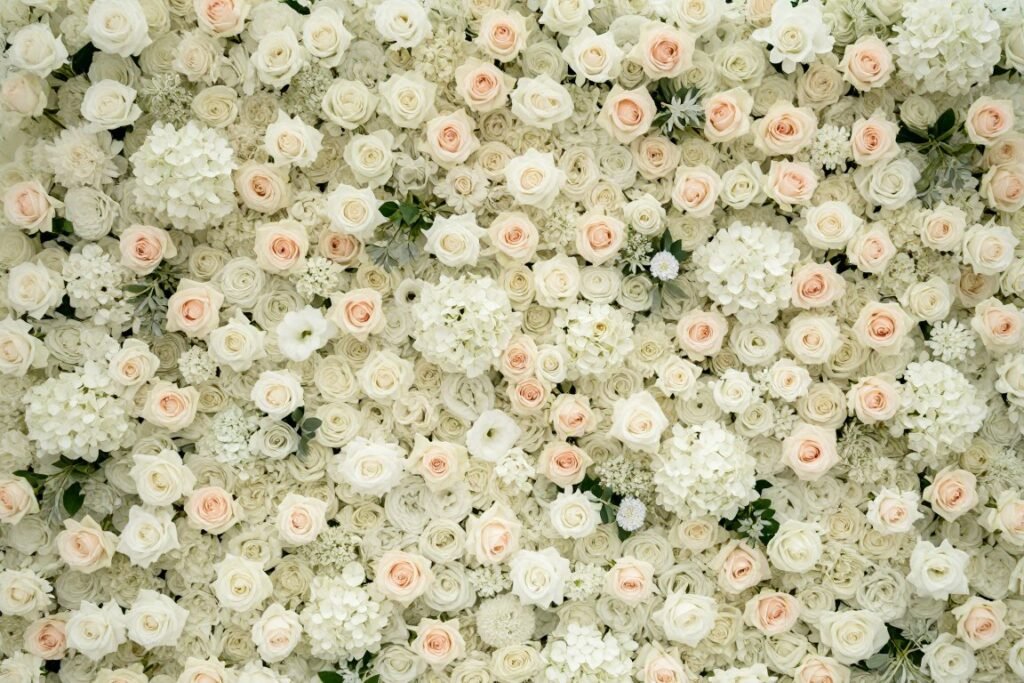 Elegant wedding flower wall in white and blush tones serving as a photo backdrop
