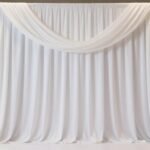 Creative Backdrop Decorations: Transform Any Space into a Stunning Setting Elegant white fabric backdrop decoration with soft draping and gentle folds for wedding ceremony