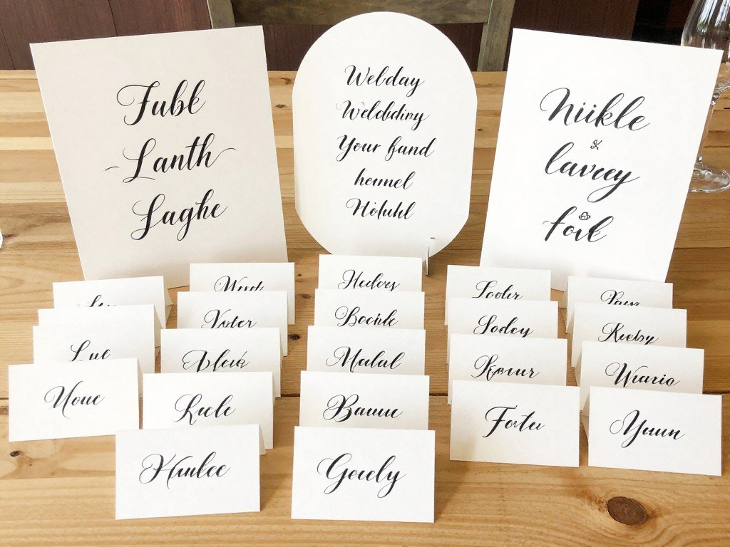 Handmade wedding place cards and signage for head table with calligraphy