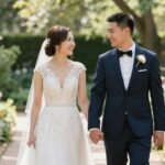 Happy couple walking hand in hand through sunlit garden path on their wedding day