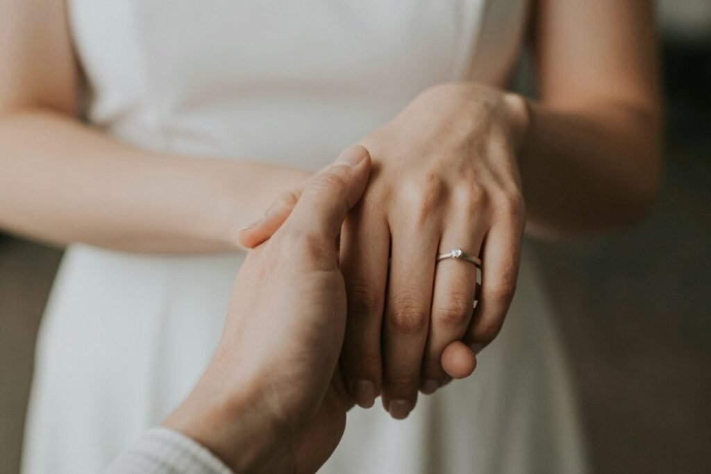 Newly engaged couple holding hands with engagement ring visible Newly engaged couple holding hands with engagement ring visible