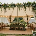 Party tent decorated with a rustic garden theme featuring greenery and soft lighting