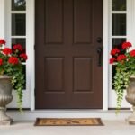 Two symmetrical classic urns with red geraniums flanking a front door, creating a timeless front porch planter arrangement