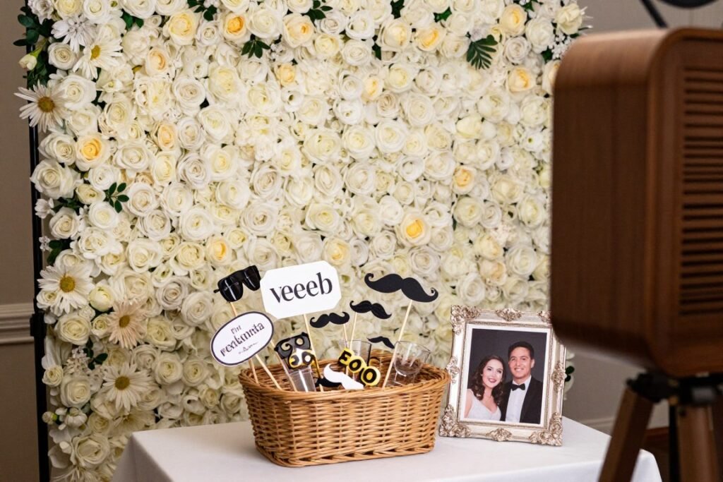 Wedding photo booth area with props and floral backdrop