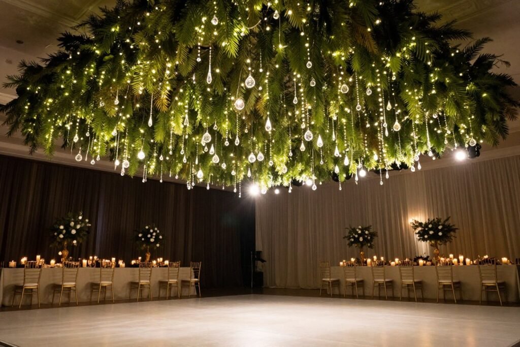 Wedding reception dance floor with suspended greenery, fairy lights, and crystal elements creating a magical canopy effect Wedding reception dance floor with suspended greenery, fairy lights, and crystal elements creating a magical canopy effect