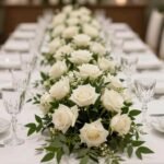 50 Stunning Wedding Table Decorations to Transform Your Reception White rose and greenery garland wedding table decoration running down the center of a long reception table