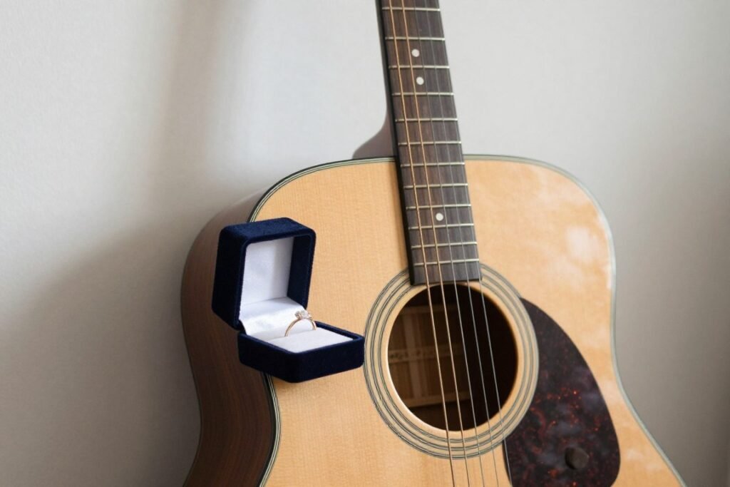 acoustic guitar leaning against wall with ring box