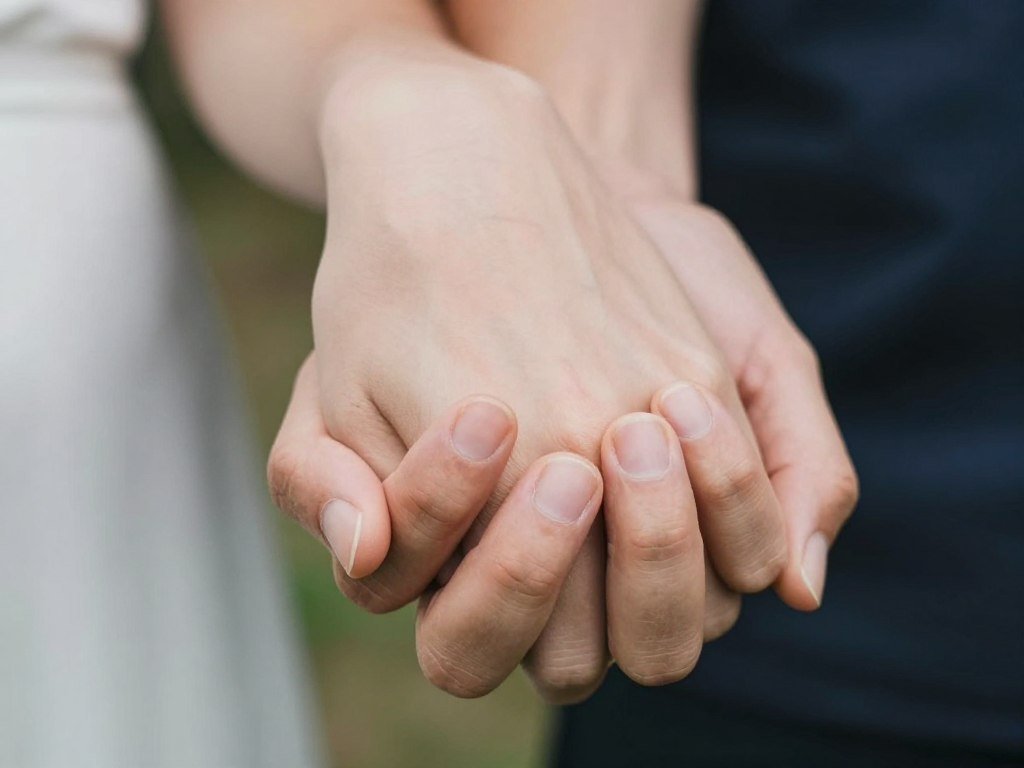 close-up of couple's hands intertwined in intimate photobooth detail shot