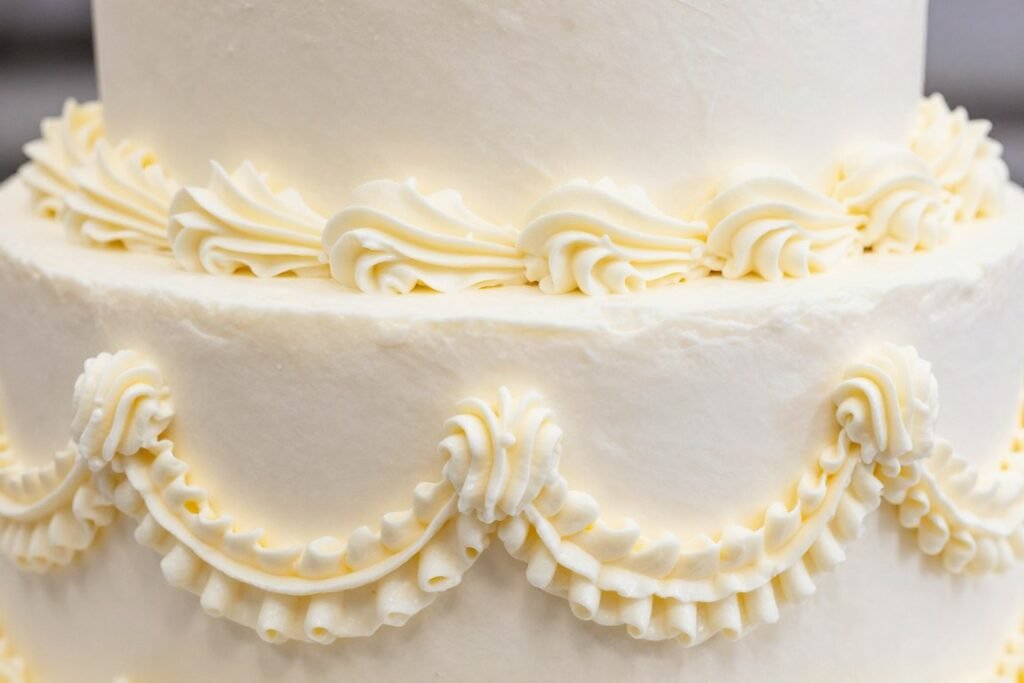 close-up of intricate buttercream piping work on white wedding cake close-up of intricate buttercream piping work on white wedding cake