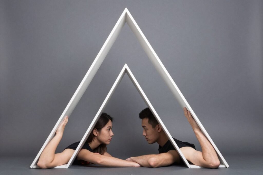 couple creating geometric triangle shape with their bodies in photobooth
