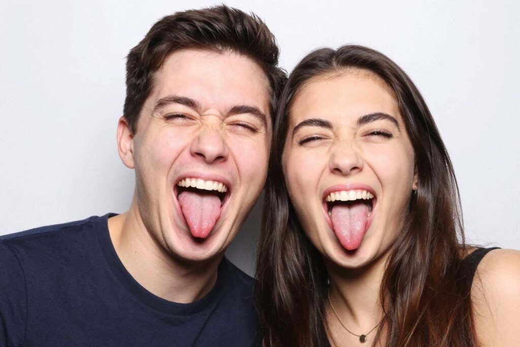 couple making silly funny faces together in photobooth with tongues out