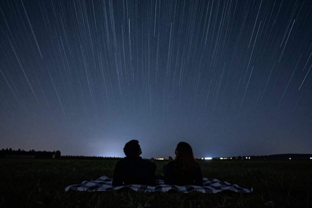 couple stargazing at night with blankets couple stargazing at night with blankets