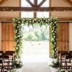 elegant barn wedding ceremony setup with fairy lights and floral arrangements