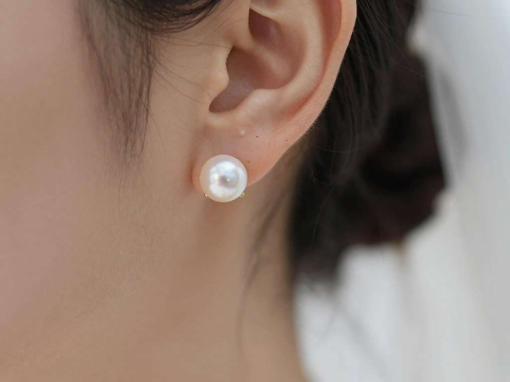 pearl stud earrings close up on bride