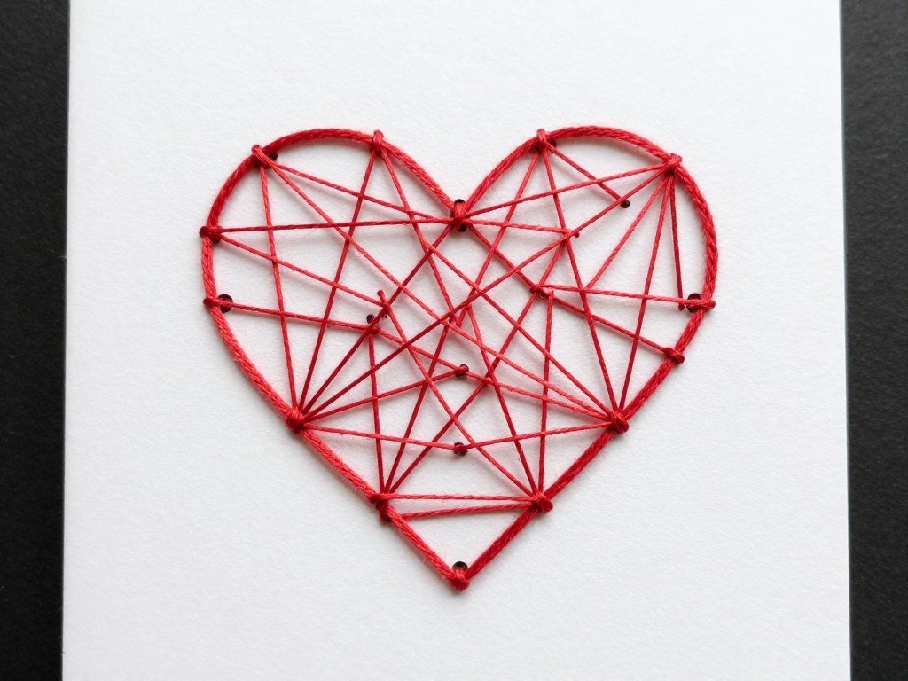 string art heart design on anniversary card with red thread on white background