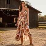 Elegant western wedding guest outfit featuring floral maxi dress with cowboy boots at rustic barn venue